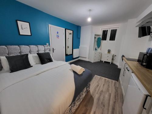 sypialnia z dużym łóżkiem i niebieską ścianą w obiekcie Nottingham Forest Rd, Short Stays w Nottingham