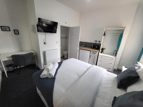 a bedroom with a white bed and a desk with a computer at Nottingham Forest Rd, Short Stays in Nottingham