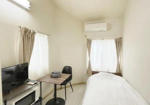 een slaapkamer met een bed en een tafel en een televisie bij Beverly Homes Osaki Room 203, Room 205, Room 301, - Vacation STAY 89062v in Tokyo