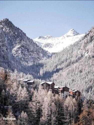 a building on the side of a snow covered mountain at Appartement aux pieds des pistes in Modane