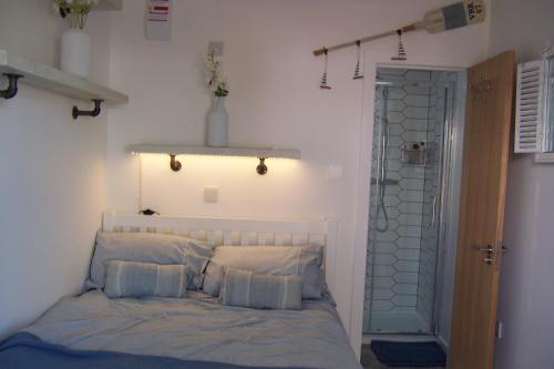 a bedroom with a bed with pillows and a door at The Whitstable, Tankerton Bolt Hole in Kent
