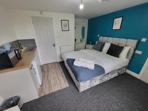 a bedroom with a large bed with a blue wall at Nottingham Forest Rd, Short Stays in Nottingham