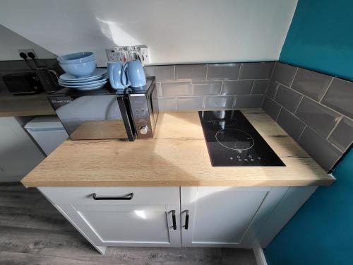 a small kitchen with a counter top with a stove at Nottingham Forest Rd, Short Stays in Nottingham