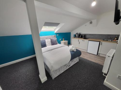 a bedroom with a bed and a blue wall at Nottingham Forest Rd, Short Stays in Nottingham