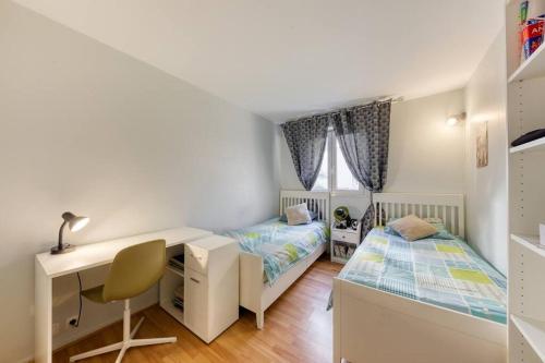 1 Schlafzimmer mit 2 Betten, einem Schreibtisch und einem Schreibtisch in der Unterkunft Superbe appartement 5P in Châtillon