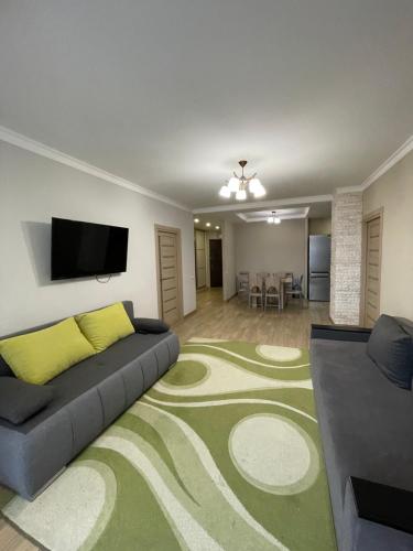 a living room with a couch and a flat screen tv at Chornovola Apartment Липинського 28 in Lviv