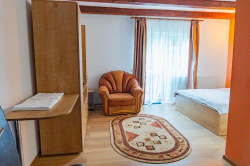 a room with a bedroom with a chair and a bed at Casa Negru Vodă Breaza in Breaza