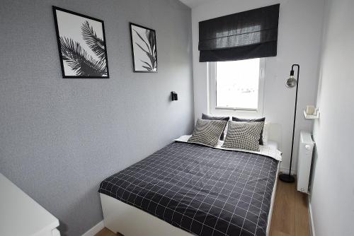 łóżko w pokoju z dwoma zdjęciami na ścianie w obiekcie Apartament West Wrocław / Parking Free we Wrocławiu