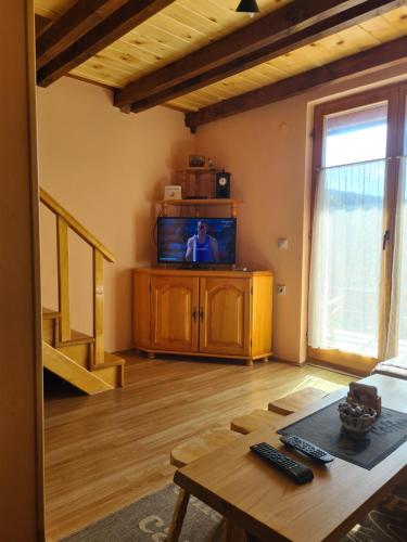 a living room with a tv and a table at Vikendica Nina in Mitrovac