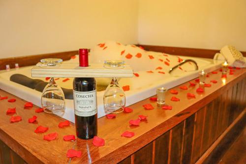 a bath tub with a bottle of wine and red paper hearts at Montanhas Do Visconde in Visconde De Maua