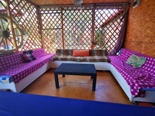 Habitación con mesa y camas de color púrpura y blanco. en Apartman LALI, en Veľký Meder