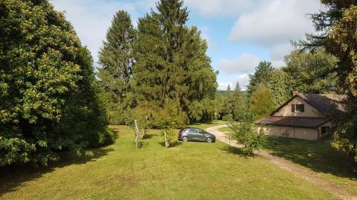 um carro estacionado num quintal ao lado de uma casa em Prince des carrés em Saint-Malo-en-Douziois