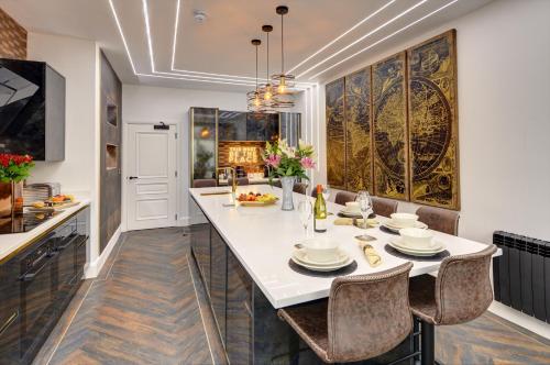 a kitchen with a large white table and chairs at Swish Luxury Holiday Apartments in Blackpool