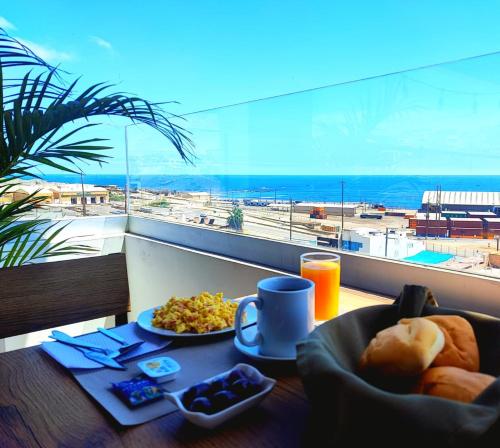 einen Tisch mit einem Teller Essen und Blick auf den Flughafen in der Unterkunft Torreblanca Hotel in Ilo