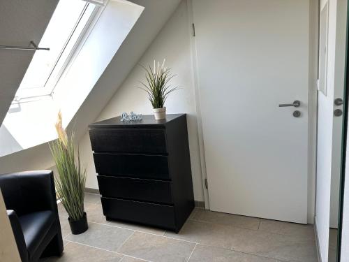 a black dresser in a room with a window at Haus Hobbingshof Greetsiel in Greetsiel