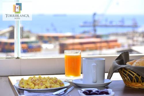 a table with a plate of food and a glass of orange juice at Torreblanca Hotel in Ilo