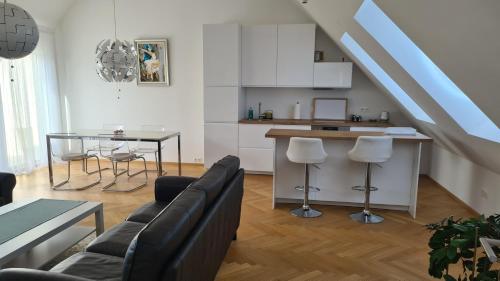 eine Küche und ein Wohnzimmer mit einem Sofa und einem Tisch in der Unterkunft TOP Apartments Kaiserebersdorf in Wien