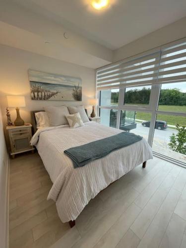 a bedroom with a large bed and a large window at 2 bedroom 2 bath Aquarius, Friday Harbour, Innisfil, Barrie in Innisfil