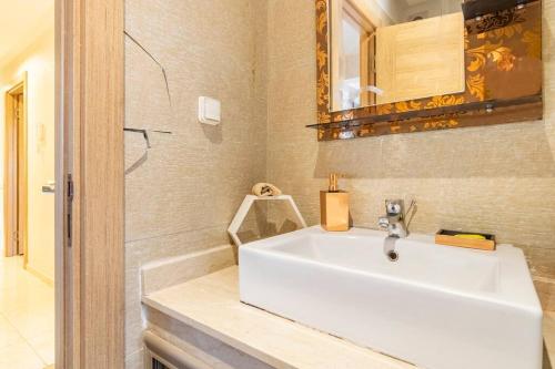een badkamer met een witte wastafel en een spiegel bij Luxury Apartment Les perles de Marrakech in Marrakesh