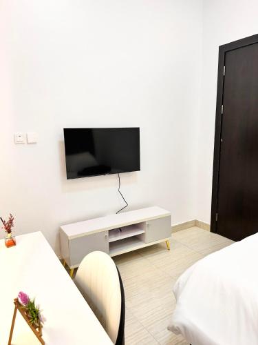 a white living room with a tv on a wall at Luxury Shortlet Apartment Ajah, Lekki Lagos in Lagos