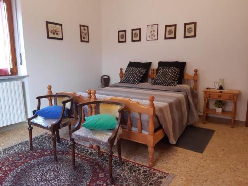a bedroom with a bed with two chairs and a table at Grazioso bilocale Merlino, luminoso con vista Santuario, wifi in Giaveno