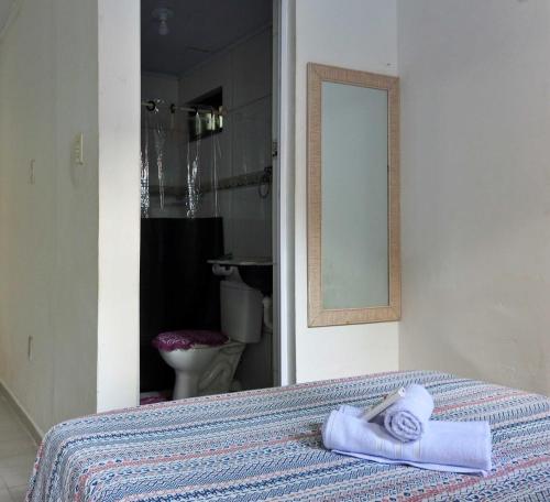 uma casa de banho com uma cama com duas toalhas em Um Paraíso no fim da rua em Barra de São Miguel