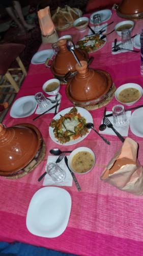 a table with plates of food on a pink table cloth at Gambi Camp in Hassilabied