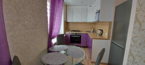 a small kitchen with a glass table and purple cabinets at Energia 2 Apartment in the city center in Narva
