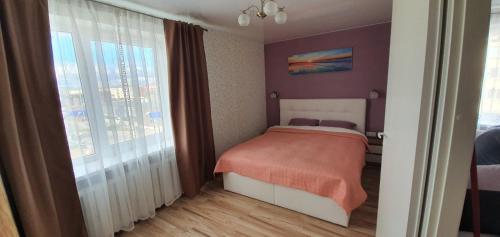 a bedroom with a bed and a large window at Energia 2 Apartment in the city center in Narva