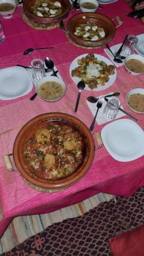 a table with plates of food on a pink table cloth at Gambi Camp in Hassilabied