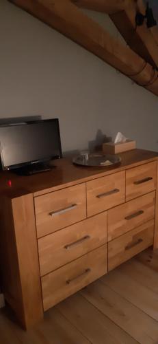 a wooden dresser with a television on top of it at annonce erronée 