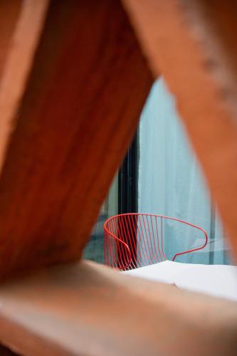 a red chair sitting in front of a window at Casa Antonieta in Oaxaca City