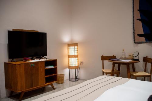 a bedroom with a bed and a television on a cabinet at Casa Antonieta in Oaxaca City