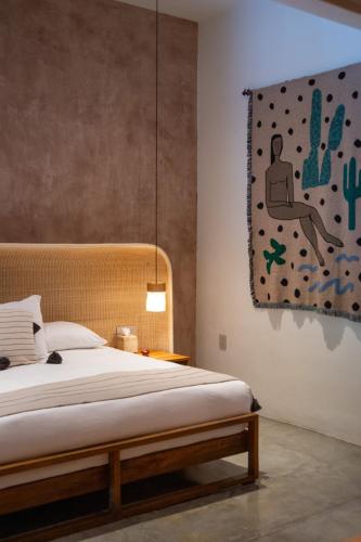a bedroom with a bed and a painting on the wall at Casa Antonieta in Oaxaca City
