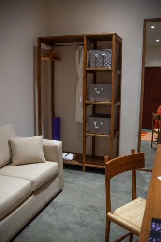 a living room with a couch and a shelf with boxes at Casa Antonieta in Oaxaca City
