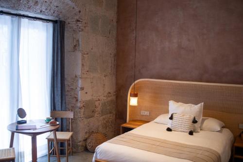 a bedroom with a bed and a table and a window at Casa Antonieta in Oaxaca City