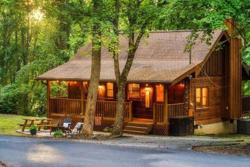 a log cabin in the woods with a tree at Couples retreat *location*hot tub*fire pit* in Pigeon Forge