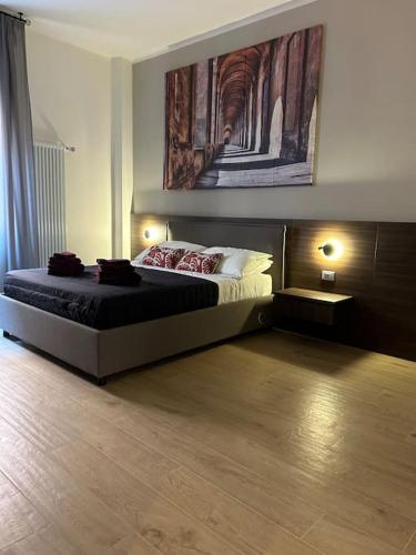 a bedroom with a bed and a painting on the wall at ALBARI HOUSE in Bologna