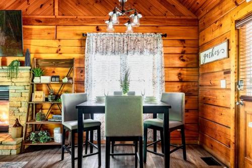 a dining room with a table and chairs and a window at Couples retreat *location*hot tub*fire pit* in Pigeon Forge