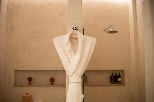 a white robe hanging on a wall in a bathroom at Casa Antonieta in Oaxaca City