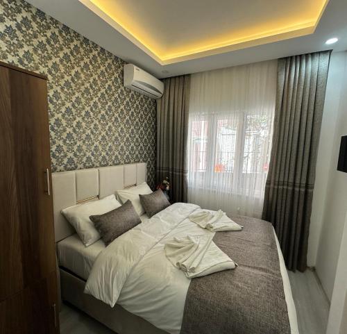 a bedroom with a large white bed in front of a window at Pera Apart in Istanbul
