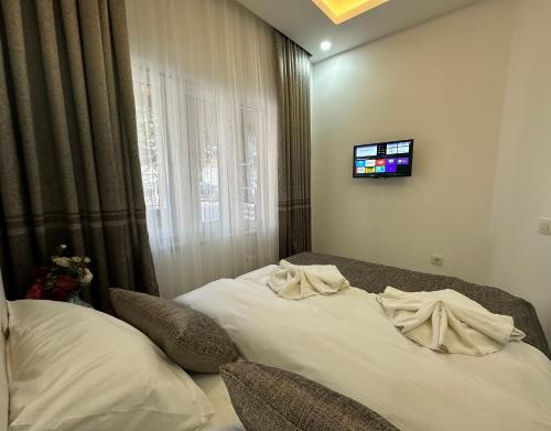 a bedroom with two beds and a tv on the wall at Pera Apart in Istanbul