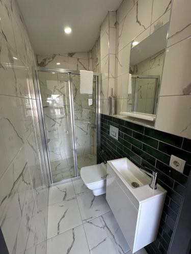 a bathroom with a sink and a shower and a toilet at Pera Apart in Istanbul