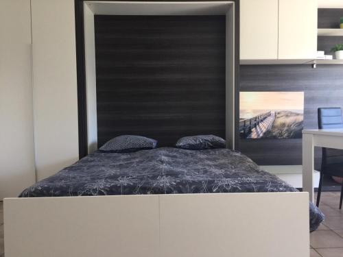 Bett mit schwarzem Kopfteil in einem Zimmer in der Unterkunft Vacances relax à Bredene in Bredene