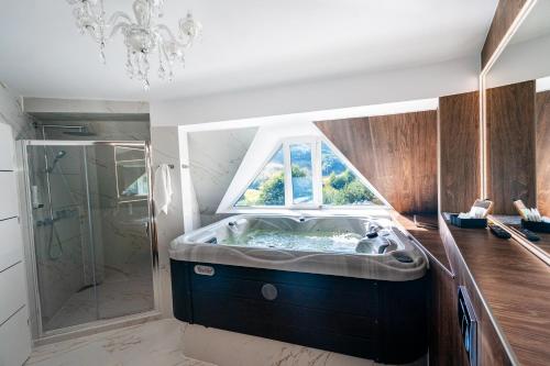 a bathroom with a bath tub with a window at Carpentiere Arena in Răşinari