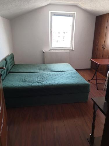 ein Schlafzimmer mit einem grünen Bett und einem Fenster in der Unterkunft ENGIN APARTMENT in Struga