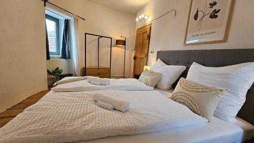 Duas camas num quarto com lençóis e almofadas brancos em YFB l 500 Jahre alter Stadtmauerturm em Dillingen an der Donau