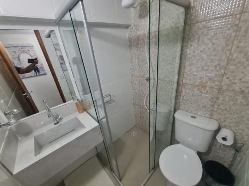 a bathroom with a toilet and a sink and a shower at Apto 18 de 2 andares com 2 quartos in Montes Claros