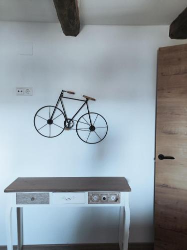a bike hanging on a wall next to a table at Casa Min in Lasieso