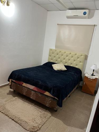 a small bedroom with a bed with a blue blanket at Casa1 in Resistencia